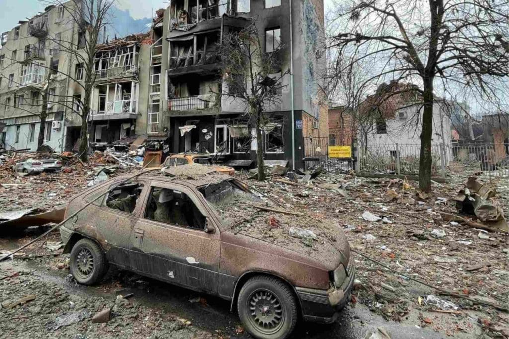 a bombed out car and building in Ukraine