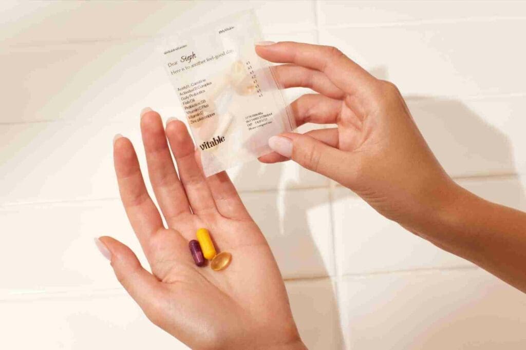 A woman's hand with a selection of Vitable vitamins in it